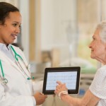 Doctor with digital tablet talking to patient